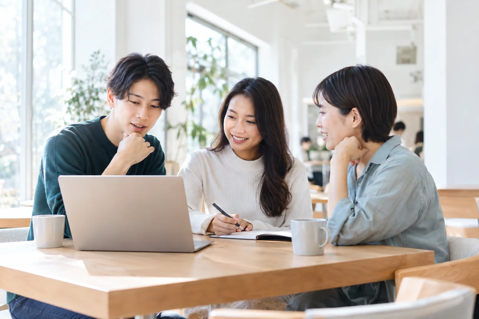 明るいオフィスで会話を交わす人々のイメージ